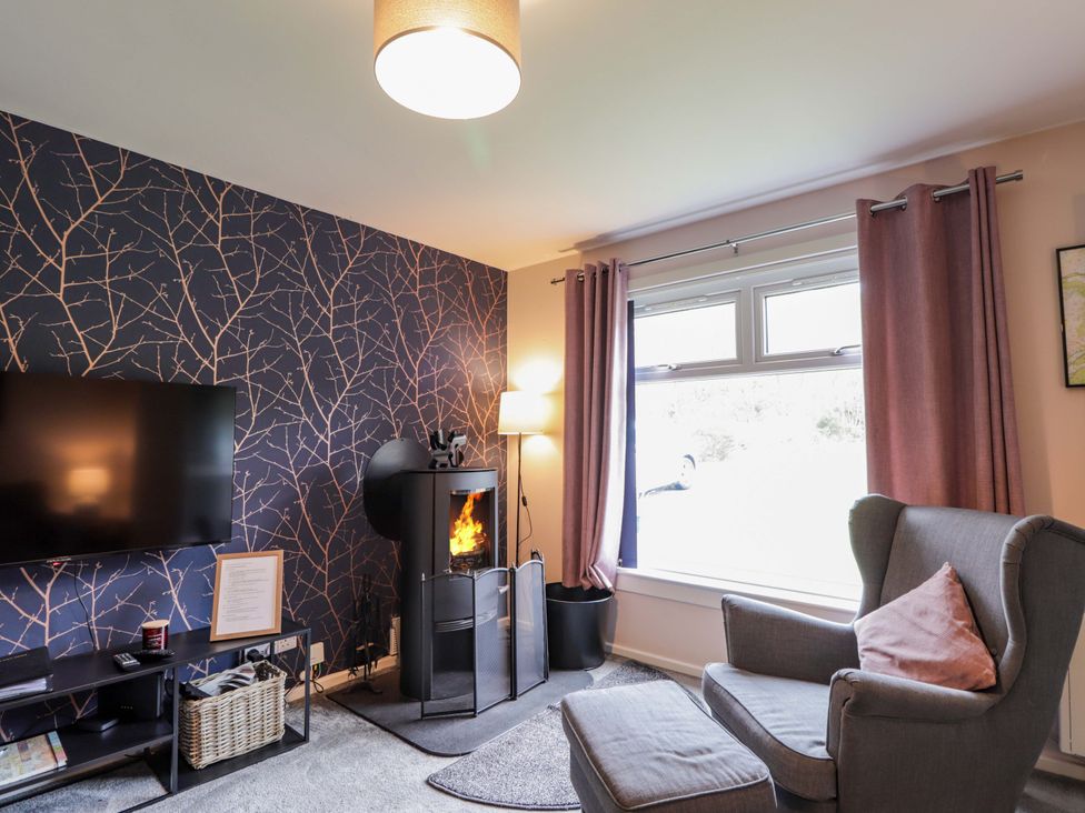 A living room with a television and a fireplace at 6 Carn Dearg in Aviemore