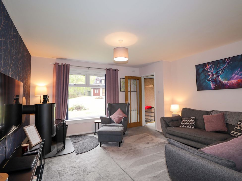 A living room with a sofa and armchair at 6 Carn Dearg in Aviemore