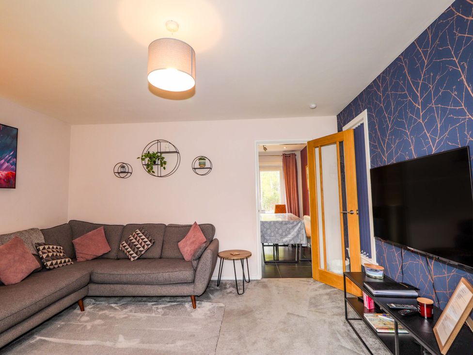 A living room with a sofa and television at 6 Carn Dearg in Aviemore