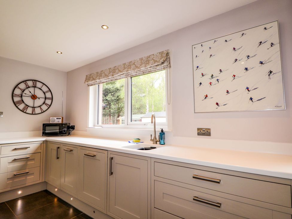 A kitchen with a window and cabinets at 6 Carn Dearg in Aviemore