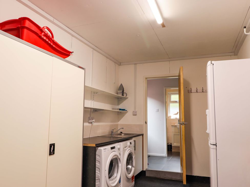 A laundry room with washing machines and a refrigerator at 6 Carn Dearg in Aviemore