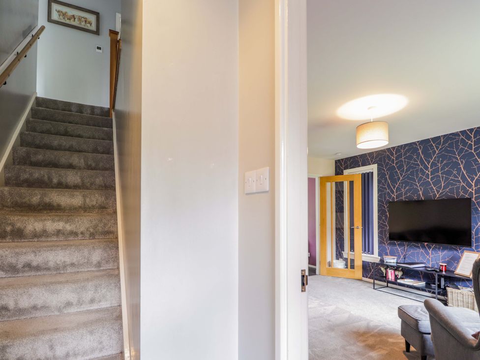 A hallway with stairs leading to an upper level at 6 Carn Dearg in Aviemore