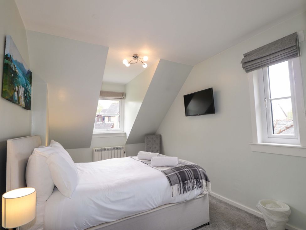 A bedroom with a bed and television at 6 Carn Dearg in Aviemore