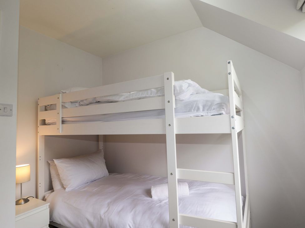 A bedroom with a bunk bed and nightstand at 6 Carn Dearg in Aviemore
