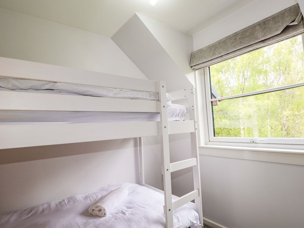A bedroom with a bunk bed and a window at 6 Carn Dearg in Aviemore