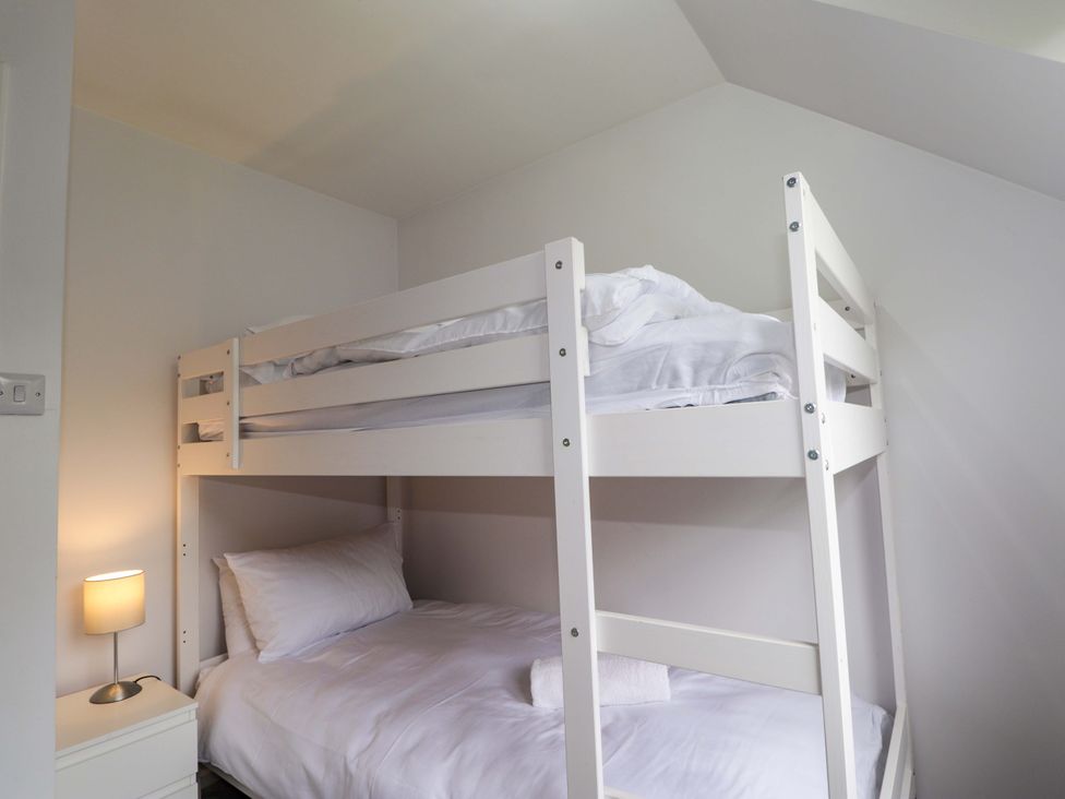 A bedroom with a bunk bed and single bed at 6 Carn Dearg in Aviemore