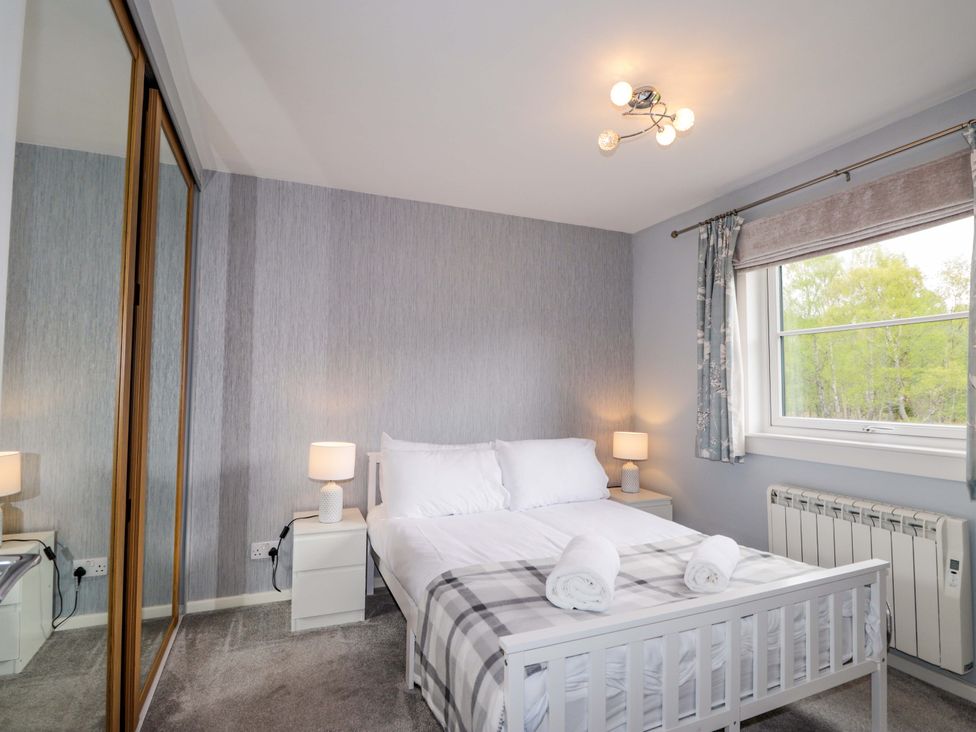 A bedroom with a bed and bedside lamps at 6 Carn Dearg in Aviemore