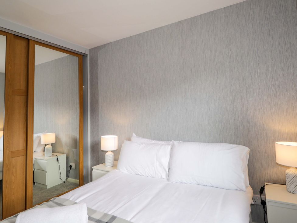 A bedroom with a bed and bedside table at 6 Carn Dearg in Aviemore