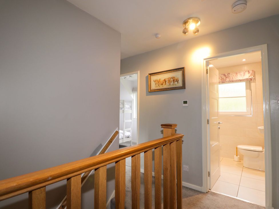 A hallway with staircase and door to bathroom at 6 Carn Dearg in Aviemore