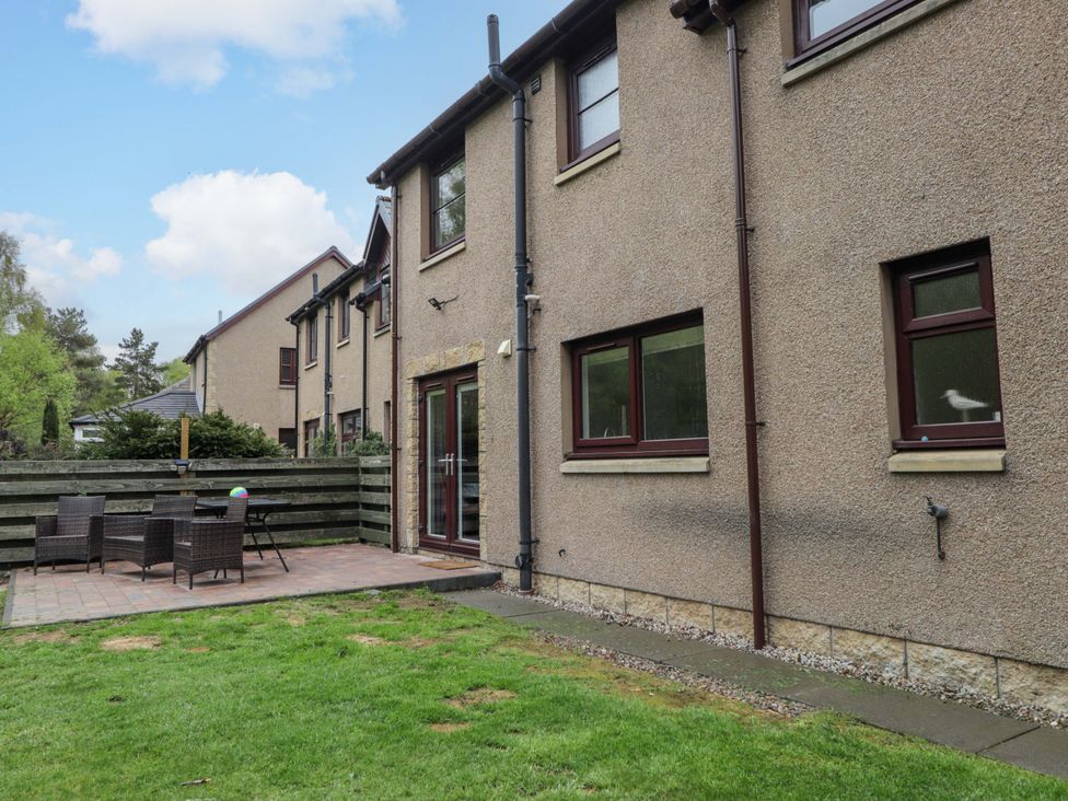 A garden with a patio and seating at 6 Carn Dearg in Aviemore