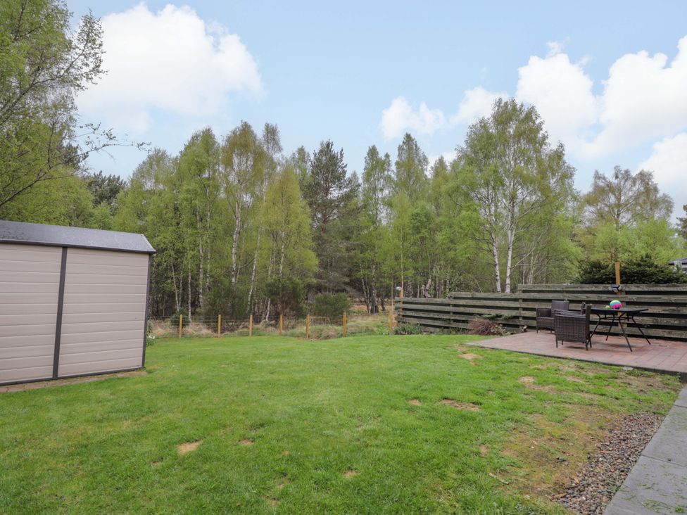 A garden with a shed and patio at 6 Carn Dearg in Aviemore