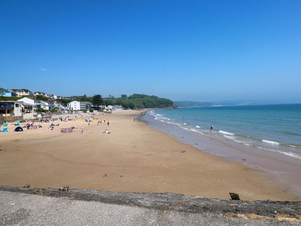 A beach with people and buildings in the background at 15 Lawnswood in Saundersfoot