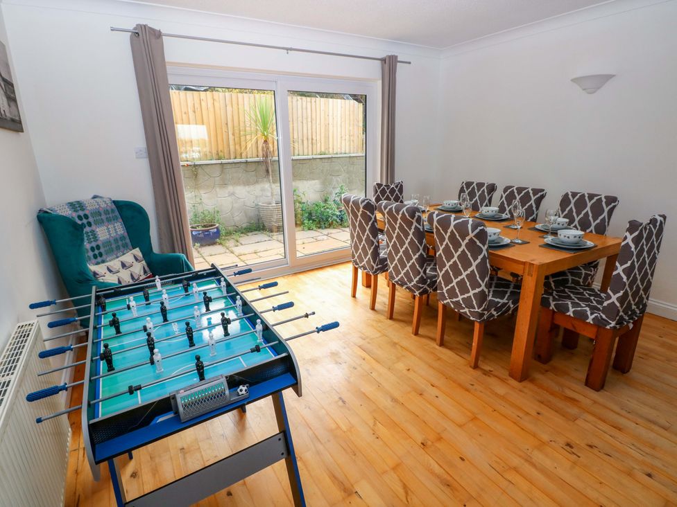 A dining room with a foosball table and dining table at 15 Lawnswood in Saundersfoot