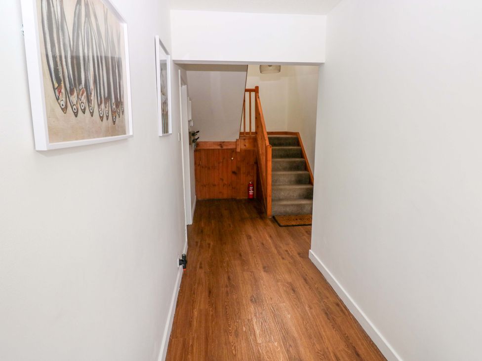 A hallway with a staircase and picture frames at 15 Lawnswood Saundersfoot
