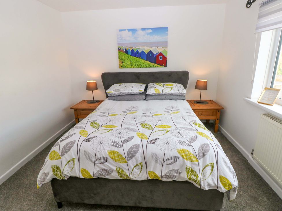 A bedroom with a bed and bedside tables at 15 Lawnswood in Saundersfoot