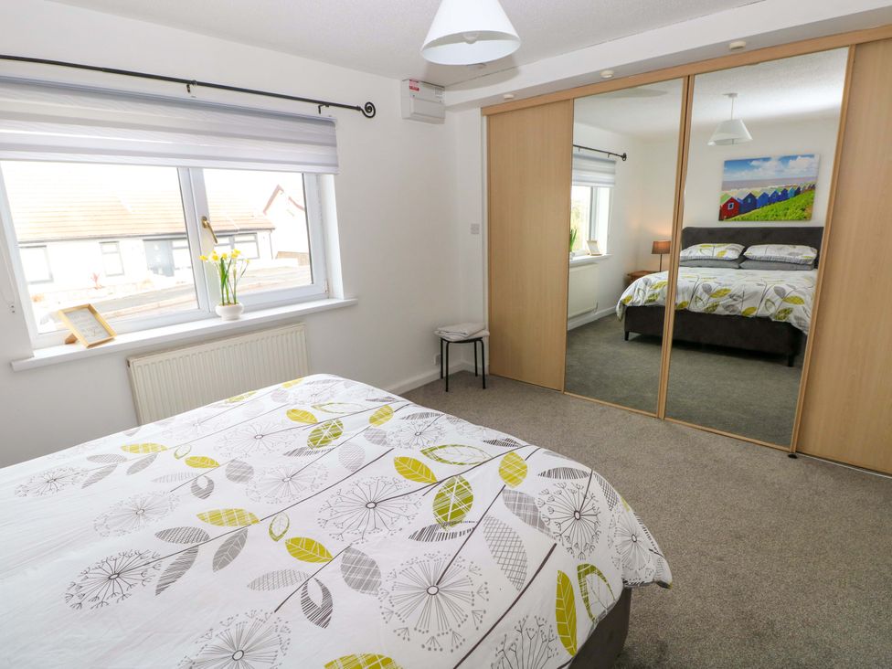A bedroom with a bed and wardrobe at 15 Lawnswood in Saundersfoot