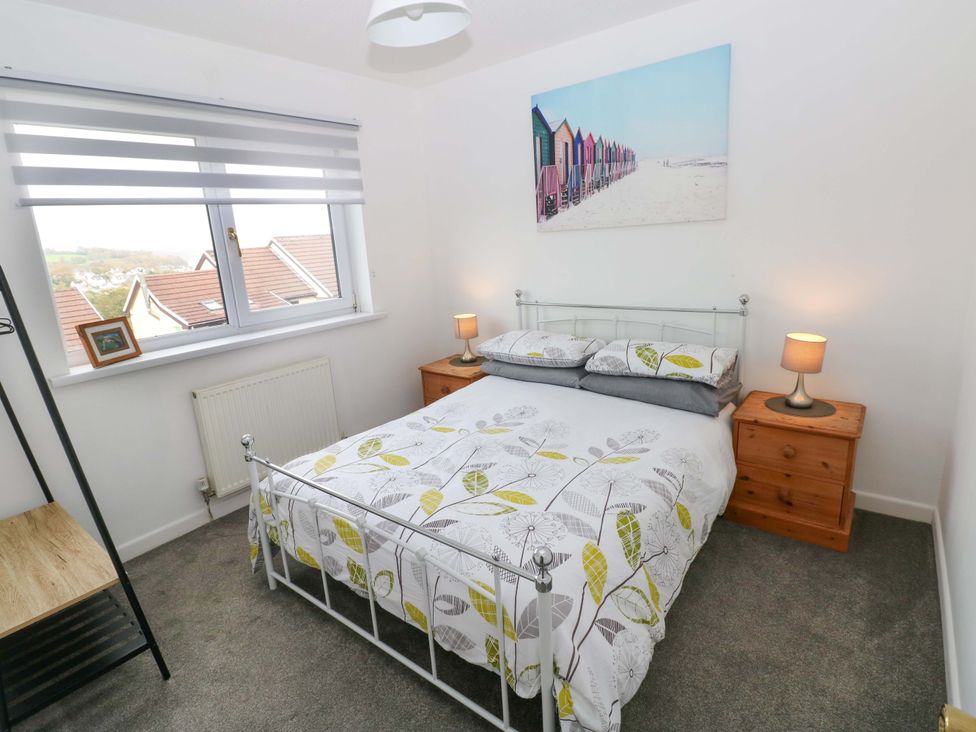 A bedroom with a bed and bedside tables at 15 Lawnswood in Saundersfoot
