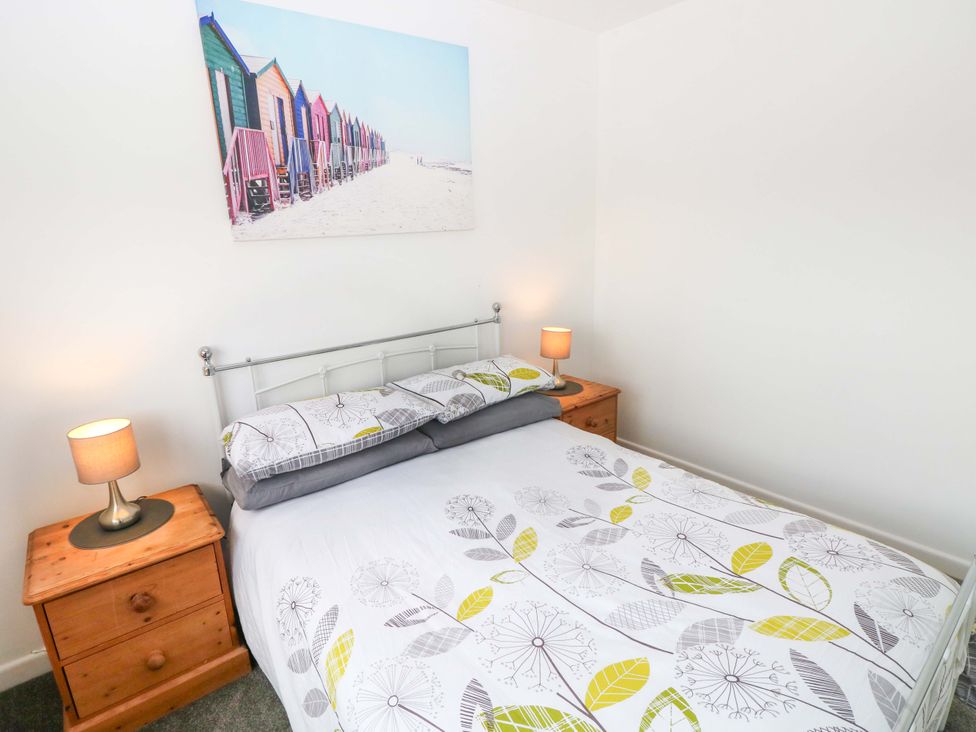 A bedroom with a bed, bedside tables and lamps at 15 Lawnswood in Saundersfoot