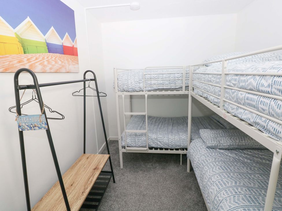 A bedroom with bunk beds and a clothing rack at 15 Lawnswood in Saundersfoot