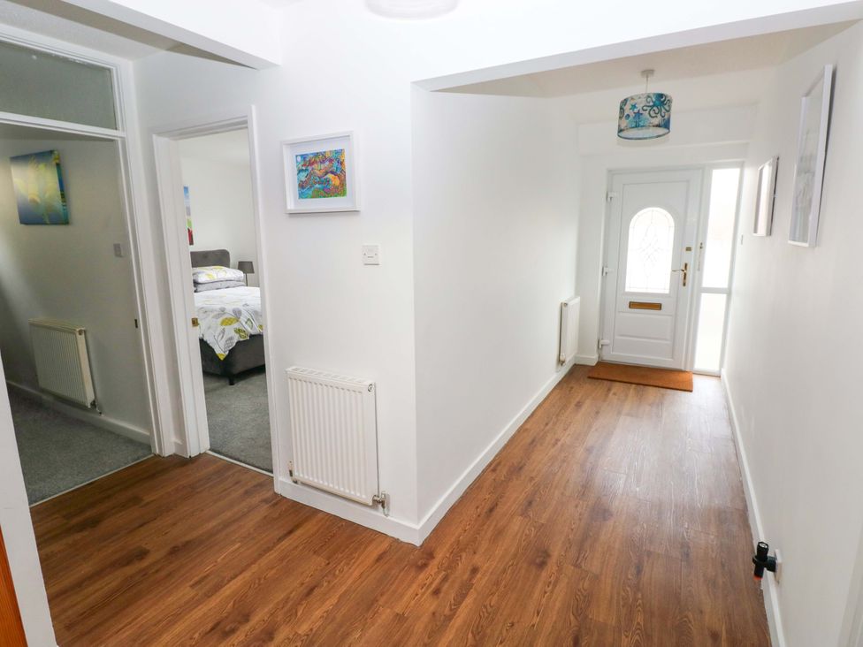 A hallway with a door and a radiator at 15 Lawnswood in Saundersfoot