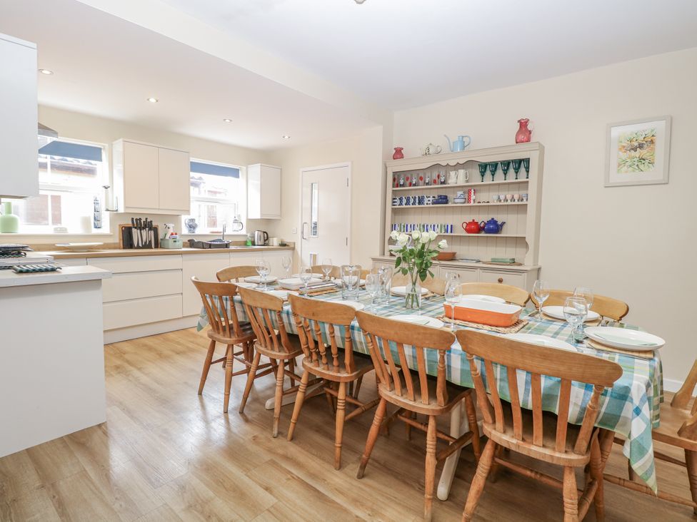 A dining room with a table set with dishes and glassware at Beach House Winterton-On-Sea