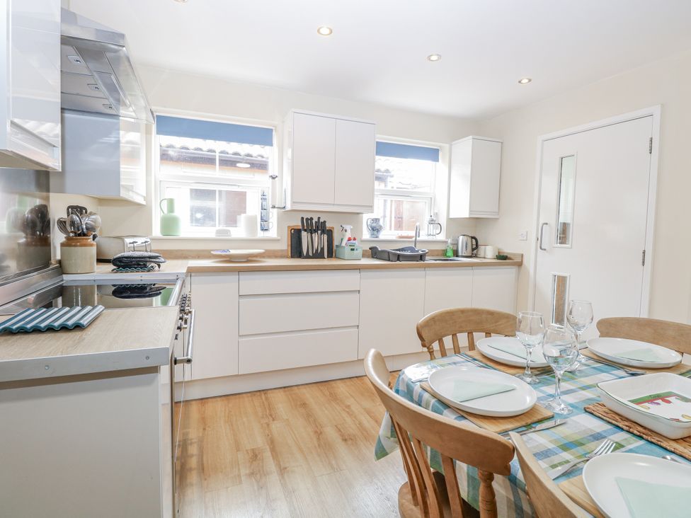 A kitchen with a dining table and chairs at Beach House Winterton-On-Sea