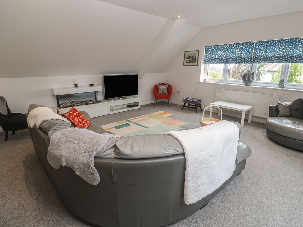 A living room with a sofa and television at Chy Holly in Carbis Bay