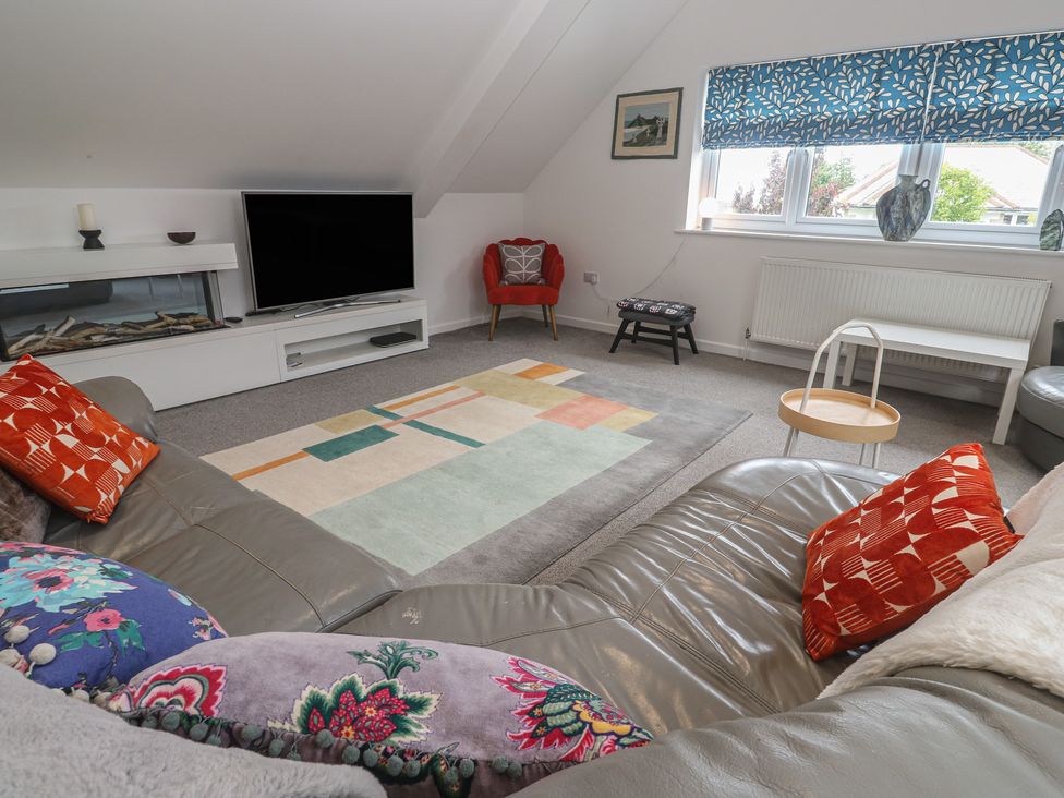 A living room with a television and sofa at Chy Holly in Carbis Bay