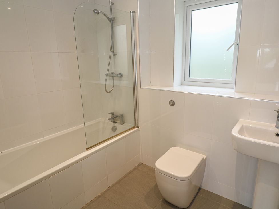 A bathroom with a bathtub, toilet, shower, and sink at Chy Holly in Carbis Bay