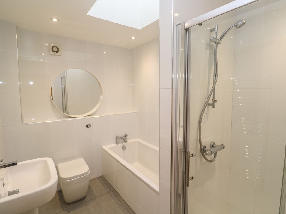 A bathroom with a shower, bathtub, sink, and toilet at Chy Holly in Carbis Bay