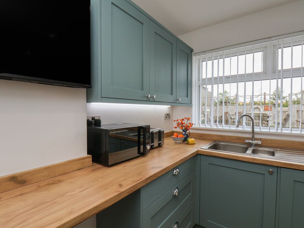 A kitchen with a sink and microwave at Sea Roke in Filey