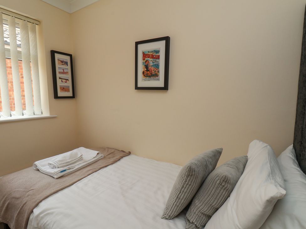 A bedroom with a bed and framed pictures at Sea Roke in Filey