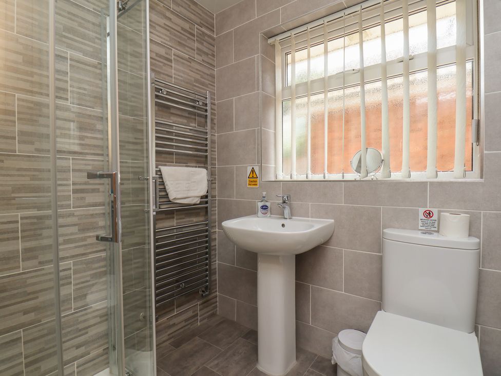 A bathroom featuring a shower, sink, toilet and towel rail at Sea Roke, Filey