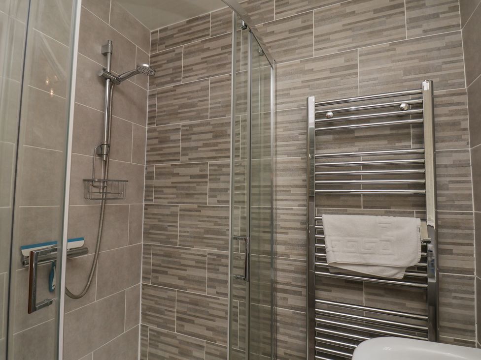 A bathroom with a shower and towel rail at Sea Roke in Filey