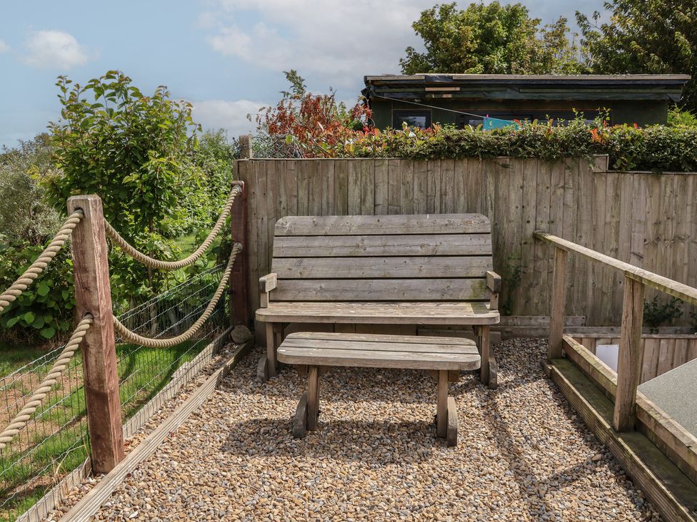 A garden area with a wooden bench and gravel at Sea Roke in Filey