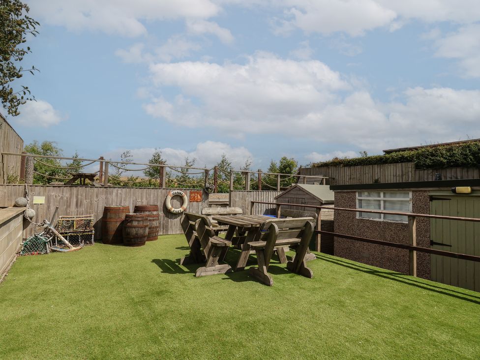 A garden with a table and benches at Sea Roke in Filey