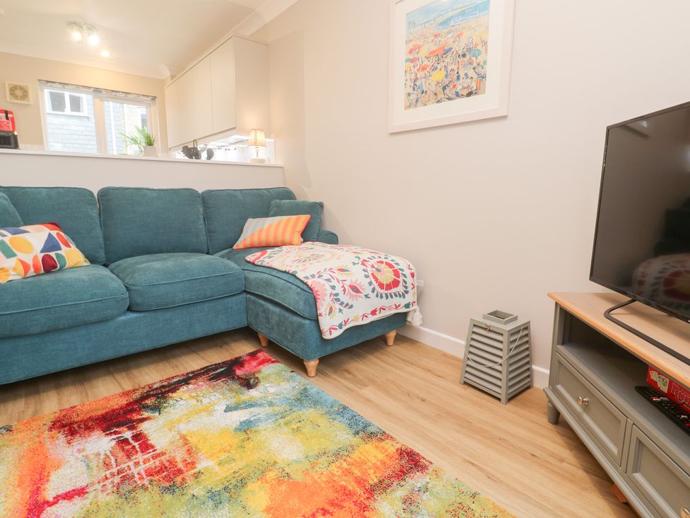 A living room with a sofa and television at Jaspers Retreat, formerly known as Starfish Cottage, Falmouth