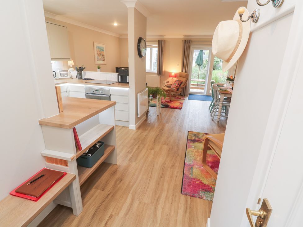 A kitchen with storage and seating area at Jaspers Retreat, formerly known as Starfish Cottage, Falmouth