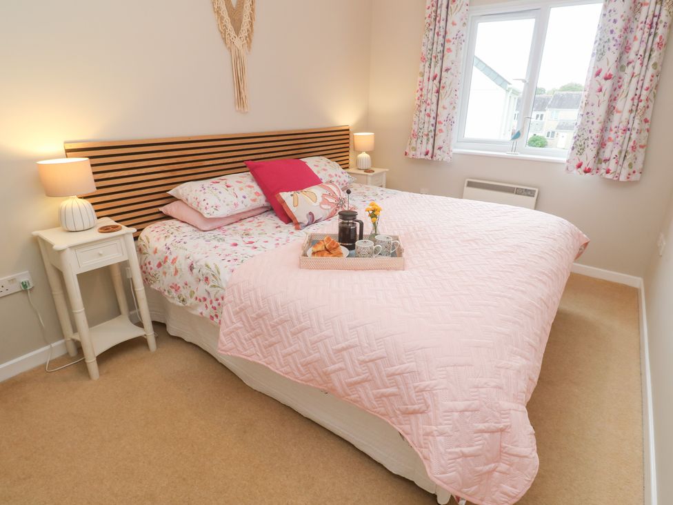 A bedroom with a bed and bedside tables at Jaspers Retreat, formerly known as Starfish Cottage, Falmouth