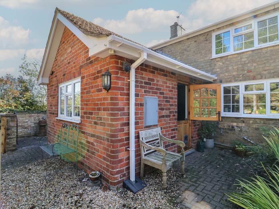 An outdoor area with a brick wall and a bench at Larkspur Cottage in Alford
