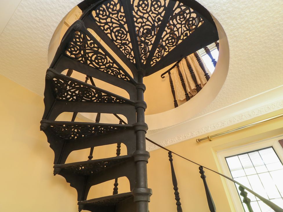 A spiral staircase leading to an upper level at Larkspur Cottage in Alford
