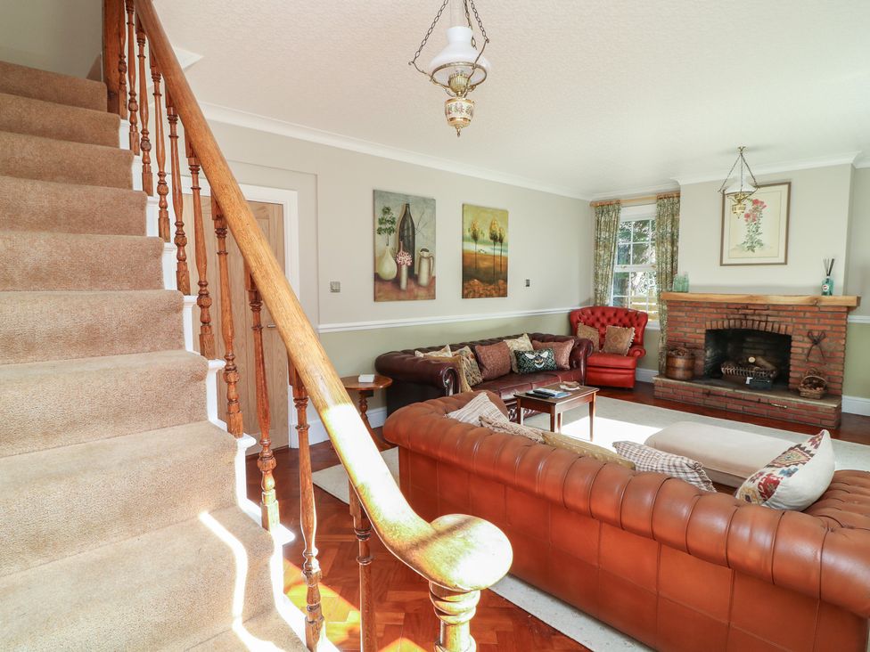 A living room with stairs leading to upper level at Larkspur Cottage in Alford