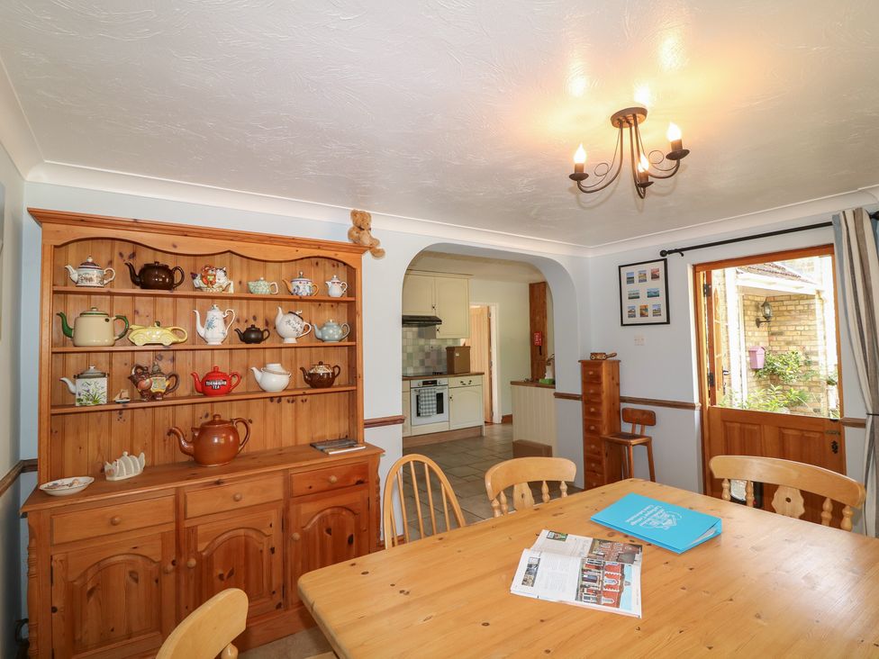 A kitchen with a dining table and teapots displayed at Larkspur Cottage in Alford