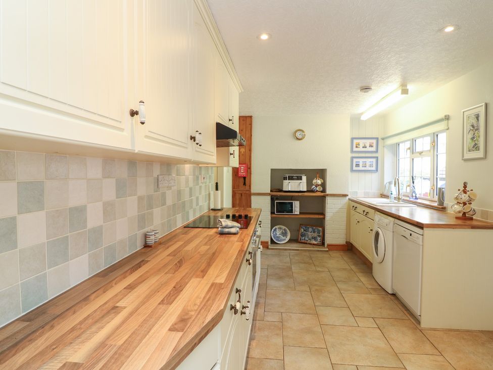 A kitchen with cabinets and appliances at Larkspur Cottage in Alford