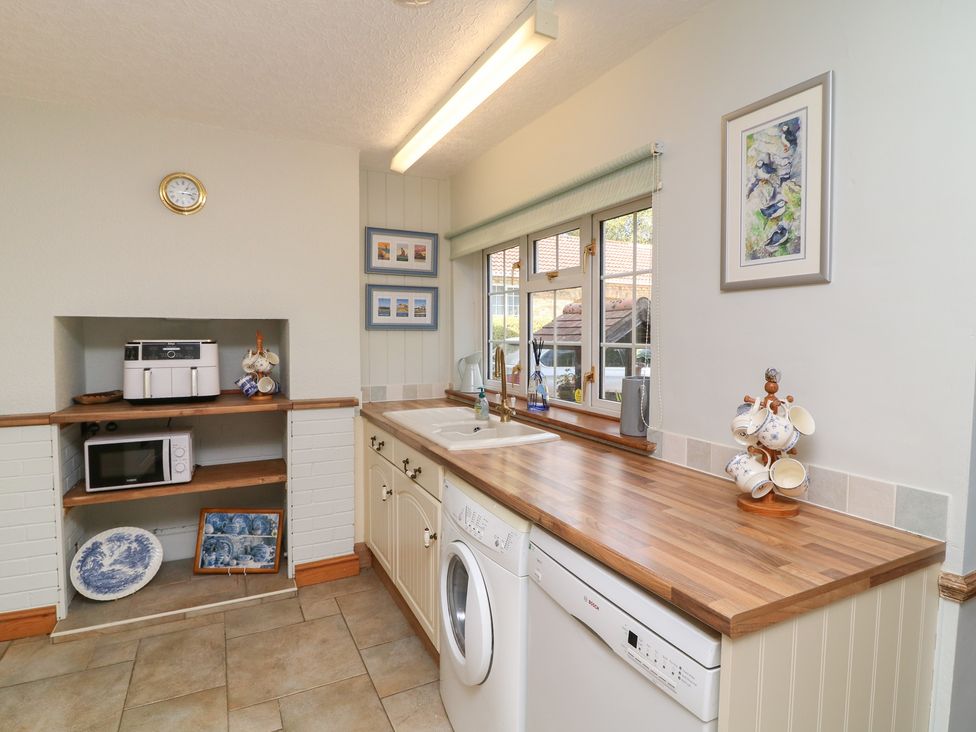 A kitchen with a sink and appliances at Larkspur Cottage in Alford