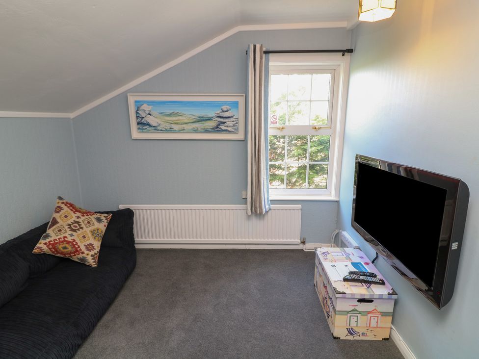 A living room with a sofa and television at Larkspur Cottage Alford