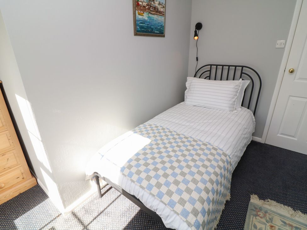 A bedroom with a single bed and a painting on the wall at Larkspur Cottage in Alford