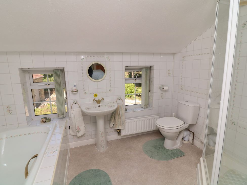 A bathroom with a washbasin, shower, and bathtub at Larkspur Cottage in Alford