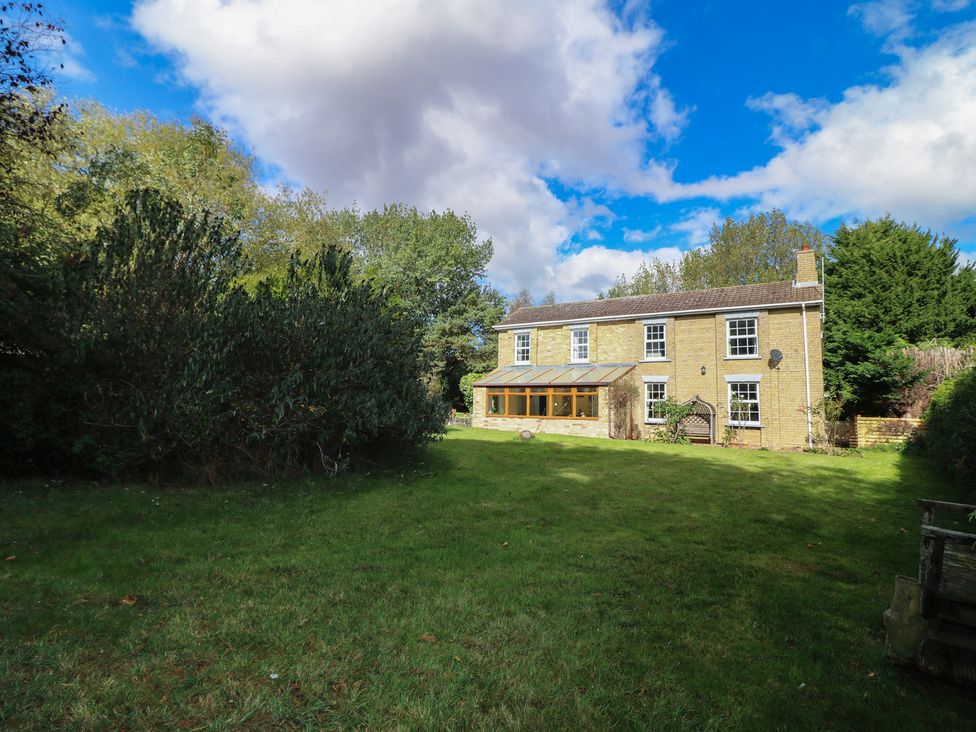 A house with a garden and trees at Larkspur Cottage in Alford