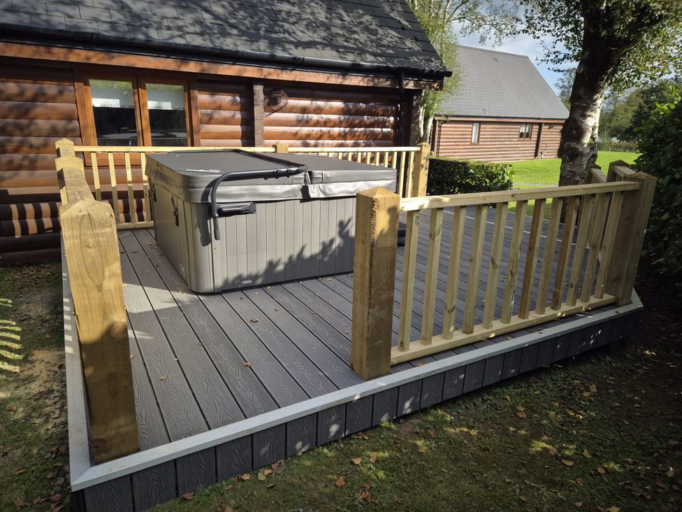 An outdoor area with a hot tub on a deck at Willow in Dolton
